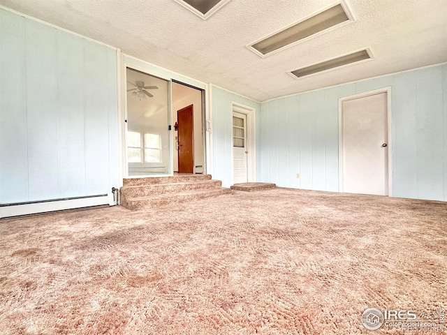 unfurnished room with a baseboard heating unit, carpet flooring, and a textured ceiling