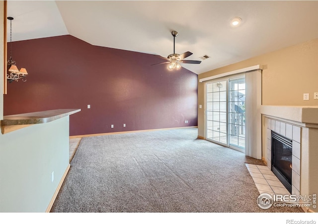 unfurnished living room featuring vaulted ceiling, light colored carpet, ceiling fan, and a fireplace