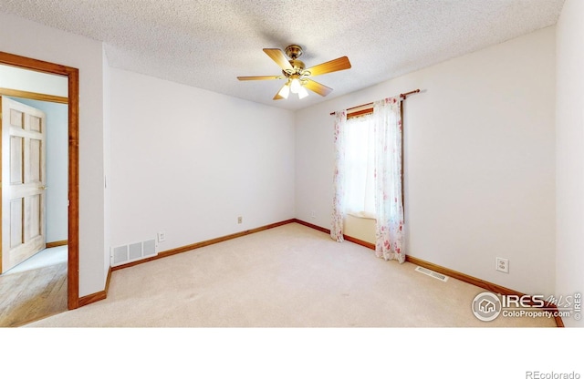 carpeted empty room with ceiling fan and a textured ceiling