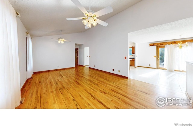 unfurnished living room with ceiling fan with notable chandelier, a textured ceiling, and light hardwood / wood-style floors