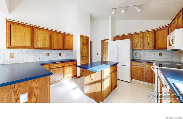 kitchen with a kitchen island, high vaulted ceiling, white appliances, and decorative backsplash