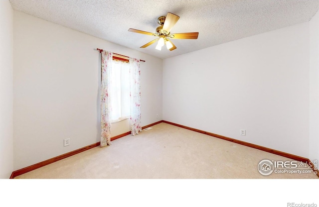 empty room with ceiling fan, light carpet, and a textured ceiling