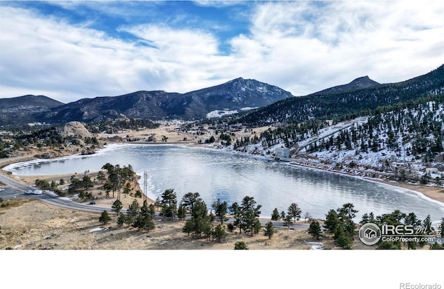 snowy aerial view with a water and mountain view