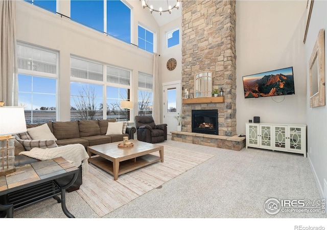 living room featuring a fireplace, carpet, a healthy amount of sunlight, and a high ceiling