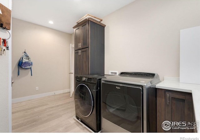 washroom with cabinets, independent washer and dryer, and light hardwood / wood-style floors