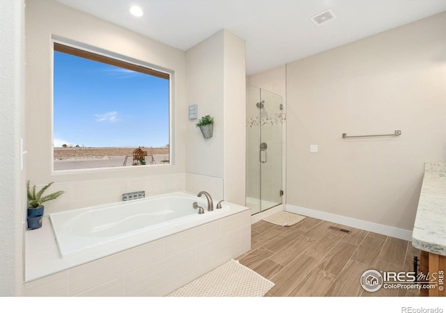 bathroom with shower with separate bathtub and vanity