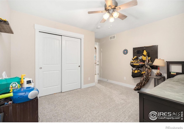 bedroom featuring light carpet, a closet, and ceiling fan