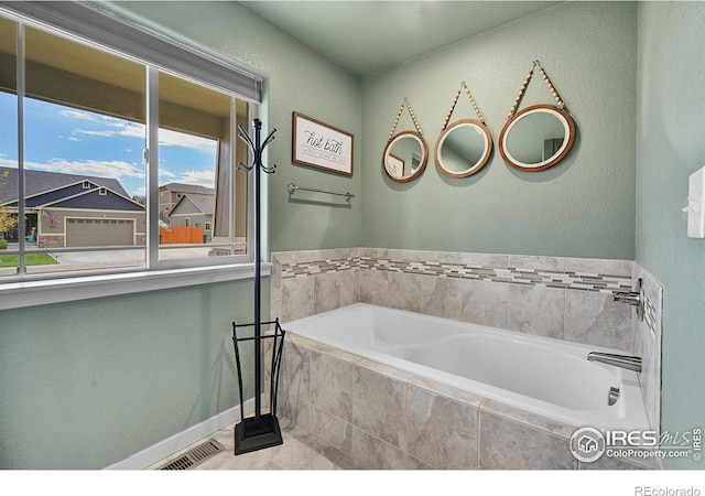 bathroom with a relaxing tiled tub