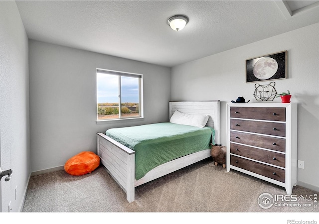 bedroom featuring a textured ceiling and carpet flooring