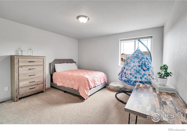 bedroom with light carpet and a textured ceiling