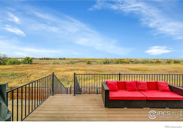 deck with an outdoor living space and a rural view