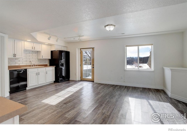 kitchen with sink, white cabinetry, backsplash, butcher block counters, and black appliances