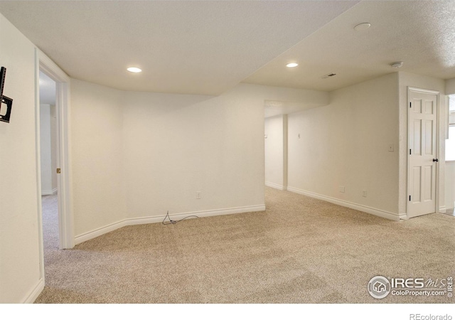 basement with light carpet and a textured ceiling