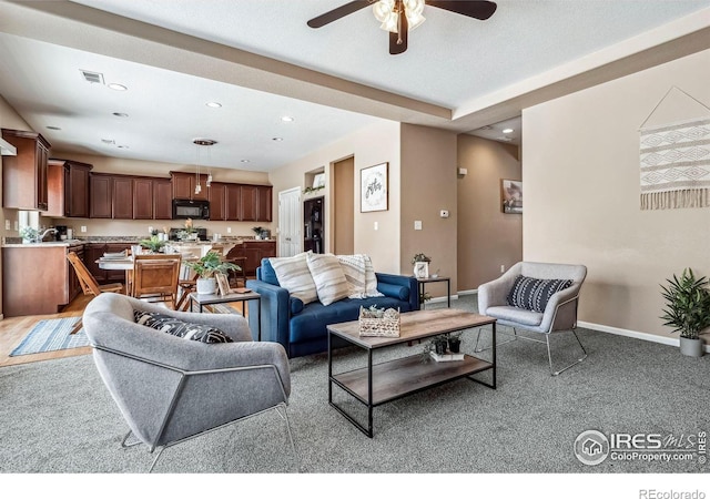 carpeted living room with ceiling fan