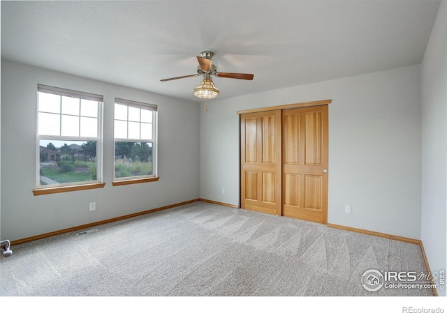 unfurnished bedroom featuring ceiling fan, carpet flooring, and a closet