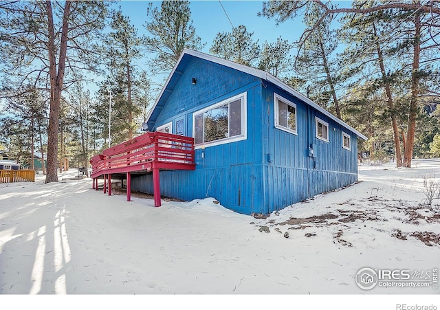 view of snow covered exterior with a wooden deck