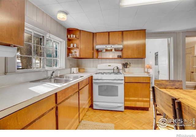 kitchen with light parquet floors, sink, and white gas range oven