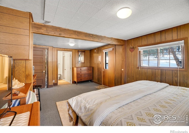 bedroom featuring carpet flooring, beamed ceiling, and wood walls