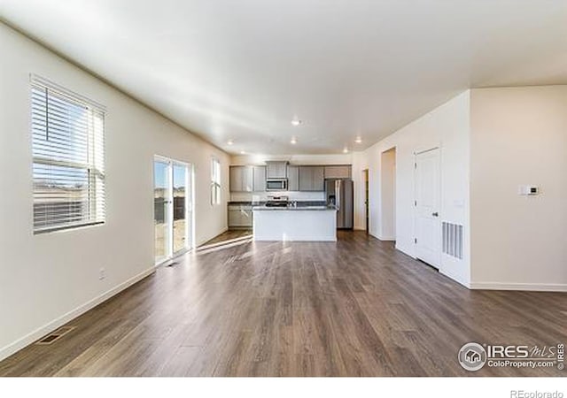 unfurnished living room with dark wood-type flooring