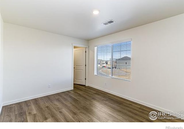 unfurnished room with dark hardwood / wood-style floors