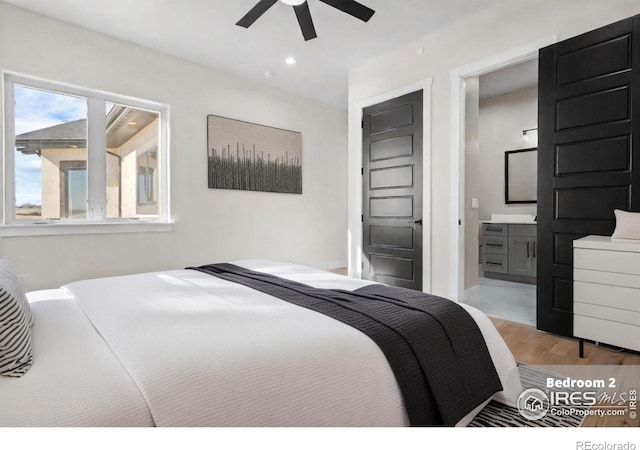 bedroom with light hardwood / wood-style flooring, ceiling fan, and ensuite bathroom