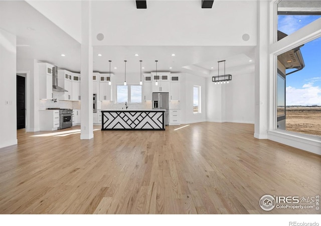 unfurnished living room with sink and light wood-type flooring