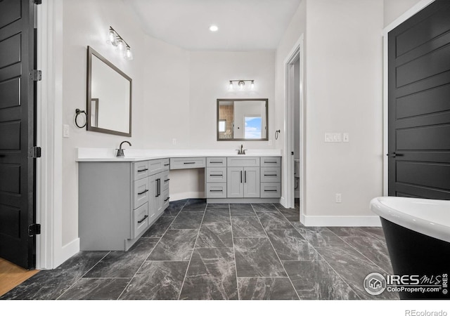 bathroom with vanity, a bathtub, and toilet