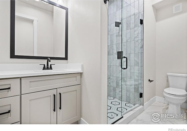 bathroom featuring a shower with door, vanity, and toilet