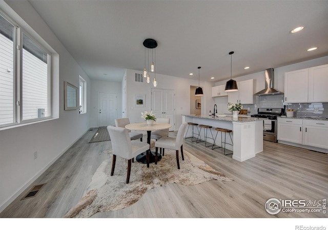 dining area with sink and light wood-type flooring