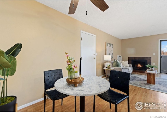 dining space featuring ceiling fan, a textured ceiling, and light wood-type flooring