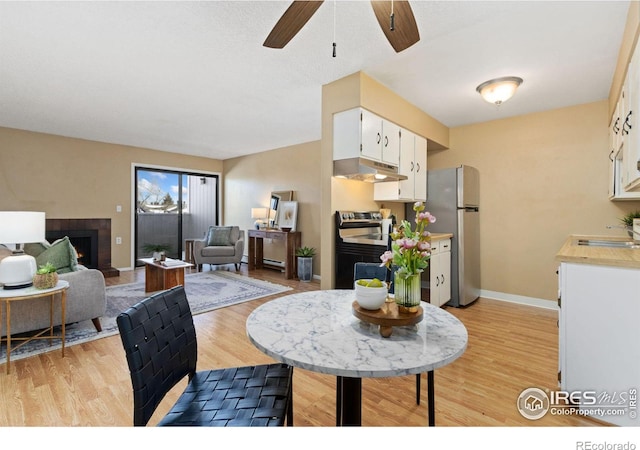 dining room with ceiling fan, sink, and light hardwood / wood-style floors