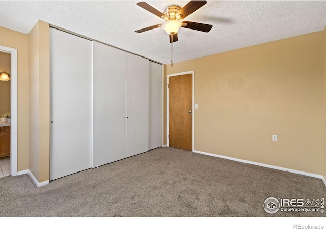 unfurnished bedroom with light colored carpet, a textured ceiling, ceiling fan, and a closet