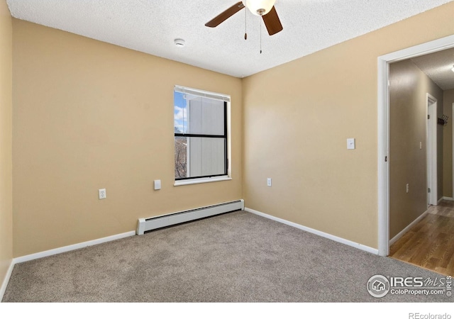 empty room featuring light carpet, a textured ceiling, and baseboard heating