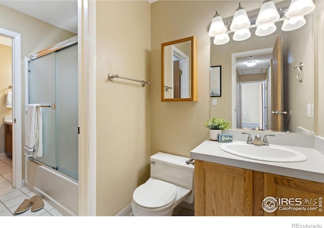 full bathroom featuring toilet, tile patterned floors, bath / shower combo with glass door, and vanity