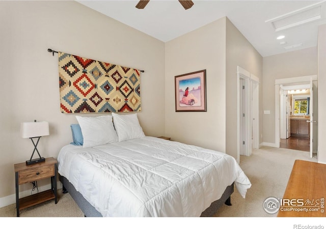 bedroom with ensuite bath, light colored carpet, and ceiling fan