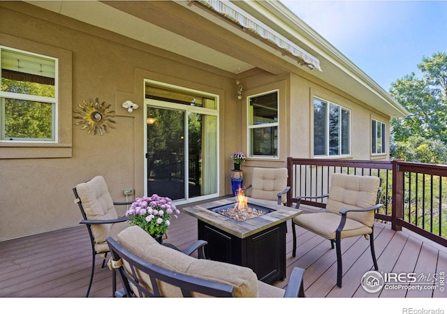 wooden deck featuring an outdoor fire pit