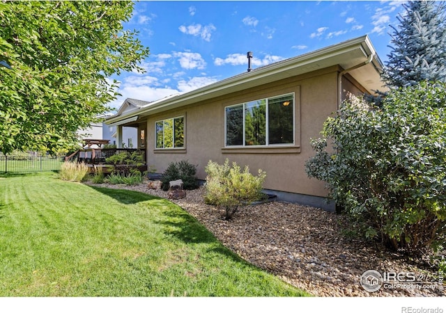 view of side of home featuring a wooden deck and a yard