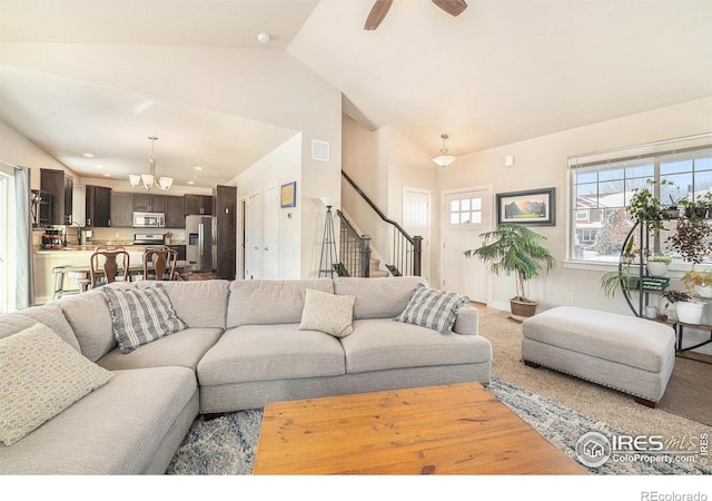 living room featuring lofted ceiling and ceiling fan with notable chandelier