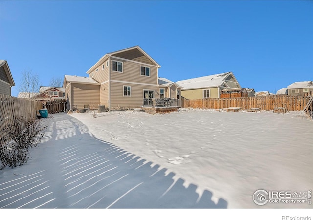 snow covered house featuring central AC