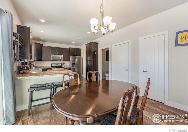 dining room with dark hardwood / wood-style flooring, a chandelier, and sink