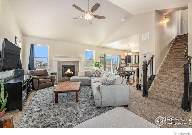 carpeted living room with vaulted ceiling, a fireplace, and ceiling fan