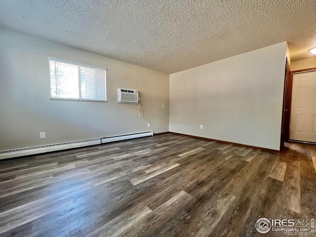 spare room featuring dark hardwood / wood-style flooring, an AC wall unit, a textured ceiling, and baseboard heating