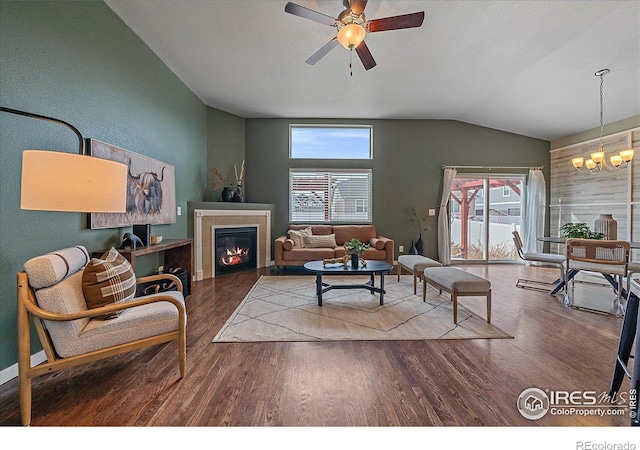 living room with a healthy amount of sunlight, a fireplace, vaulted ceiling, and wood-type flooring