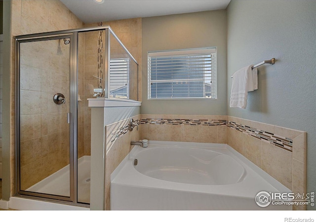 bathroom featuring independent shower and bath