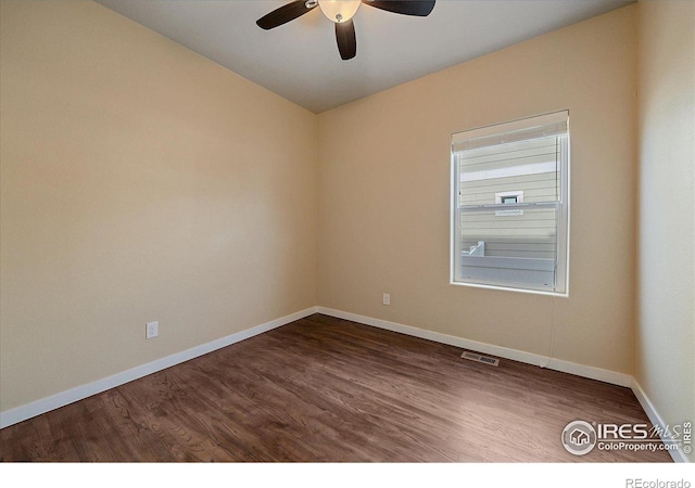 spare room featuring dark wood-type flooring and ceiling fan