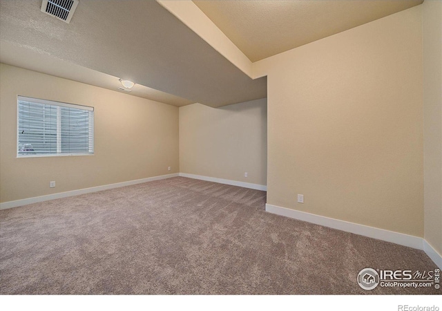 carpeted spare room with a textured ceiling