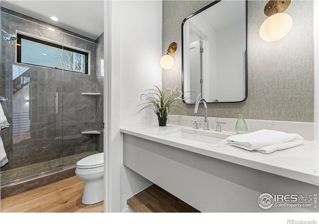 bathroom with vanity, toilet, an enclosed shower, and hardwood / wood-style floors