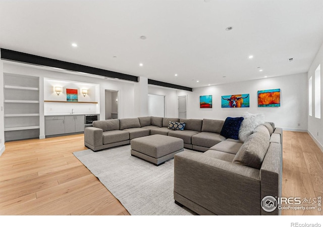 living room with wine cooler, light hardwood / wood-style flooring, and wet bar