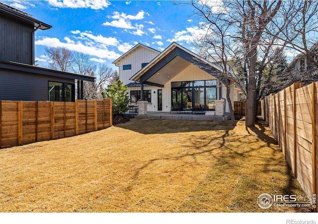 rear view of property with a patio and a lawn