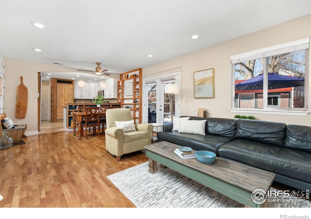 living room with french doors, ceiling fan, and light hardwood / wood-style flooring